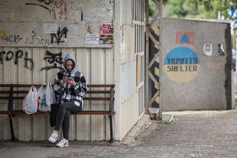 Una donna è seduta su una panchina alla fermata dell'autobus accanto a una piccola pensilina in cemento, nella città di Kramatorsk, in prima linea nel conflitto, nella regione di Donetsk, Ucraina, 27 maggio 2026. (REUTERS)