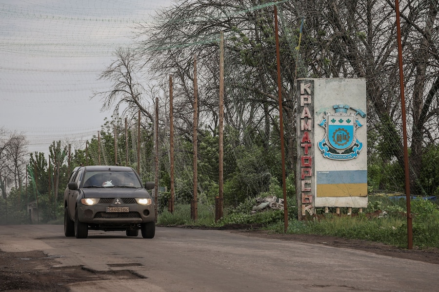 Un veicolo militare passa davanti a un cartello stradale con la scritta "Kramatorsk", alla periferia della città di Kramatorsk, in prima linea sul fronte, nella regione di Donetsk, Ucraina, 27 maggio 2026. (REUTERS)