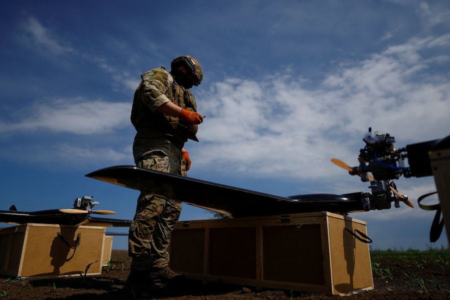 Un militare delle Forze dei sistemi senza pilota prepara dei droni da attacco a medio raggio per il lancio, in una località non specificata in Ucraina. (REUTERS)