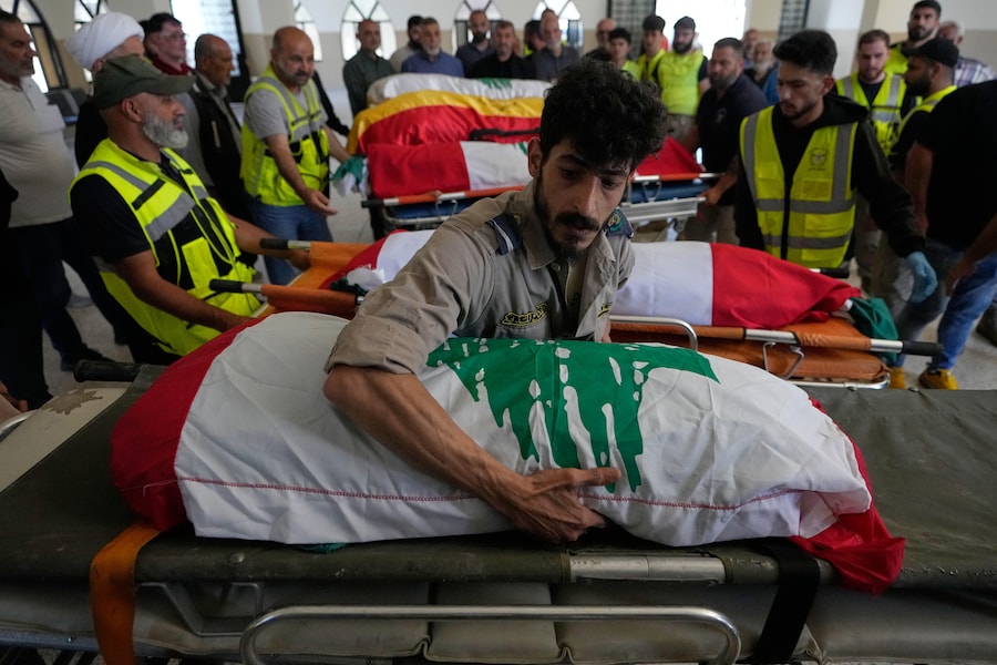 Un paramedico volontario adagia su una barella il corpo di uno dei sei membri della famiglia rimasti uccisi mercoledì, quando la loro auto è stata colpita da un attacco aereo israeliano su un'autostrada mentre fuggivano dal loro villaggio. (APN)