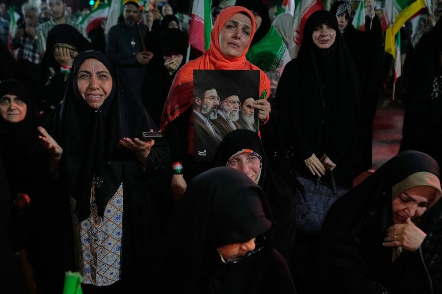 I manifestanti piangono mentre pregano; uno di loro tiene in mano un cartellone che raffigura la Guida Suprema iraniana, l'Ayatollah Mojtaba Khamenei (a sinistra), suo padre, l'Ayatollah Ali Khamenei (al centro), e il defunto fondatore della rivoluzione, l'Ayatollah Khomeini, durante una manifestazione filogovernativa in una piazza di Teheran, in Iran, venerdì 29 maggio 2026. (APN)