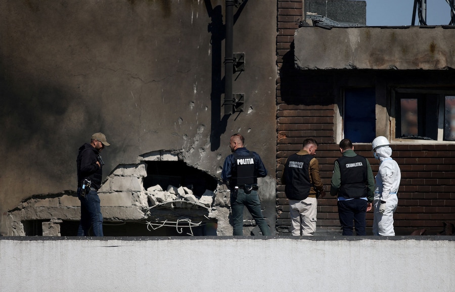 Agenti delle forze dell'ordine rumene al lavoro sul luogo di un'esplosione in un complesso residenziale a seguito dell'impatto di un drone nei pressi del confine con l'Ucraina, a Galați, in Romania, il 29 maggio 2026. (via REUTERS)