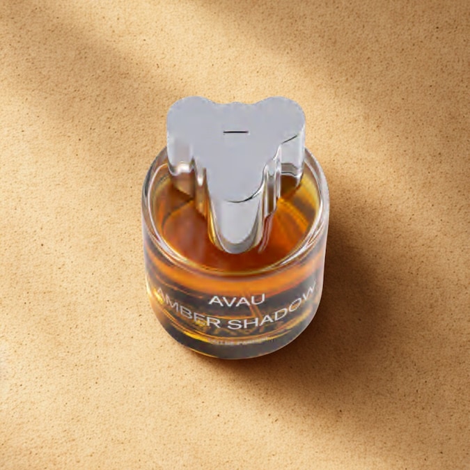 Amber Shadow di AVAU è un orientale ambrato intenso e avvolgente, dove noce moscata, zafferano e pesca incontrano la sensualità della tuberosa e del tabacco. Sul fondo, cuoio, legno di guaiaco e labdano lasciano una scia profonda, misteriosa e irresistibilmente elegante. Da notare la particolarità del tappo che chiude il flacone.