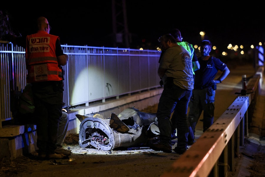 Personale di sicurezza e soccorso israeliano lavora accanto a un frammento di proiettile in seguito a un attacco missilistico dall’Iran verso Israele, nel nord del paese (REUTERS)
