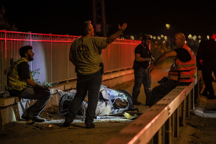 Personale di sicurezza e soccorso israeliano lavora accanto a un frammento di proiettile in seguito a un attacco missilistico dall’Iran verso Israele, nel nord del Paese (REUTERS)