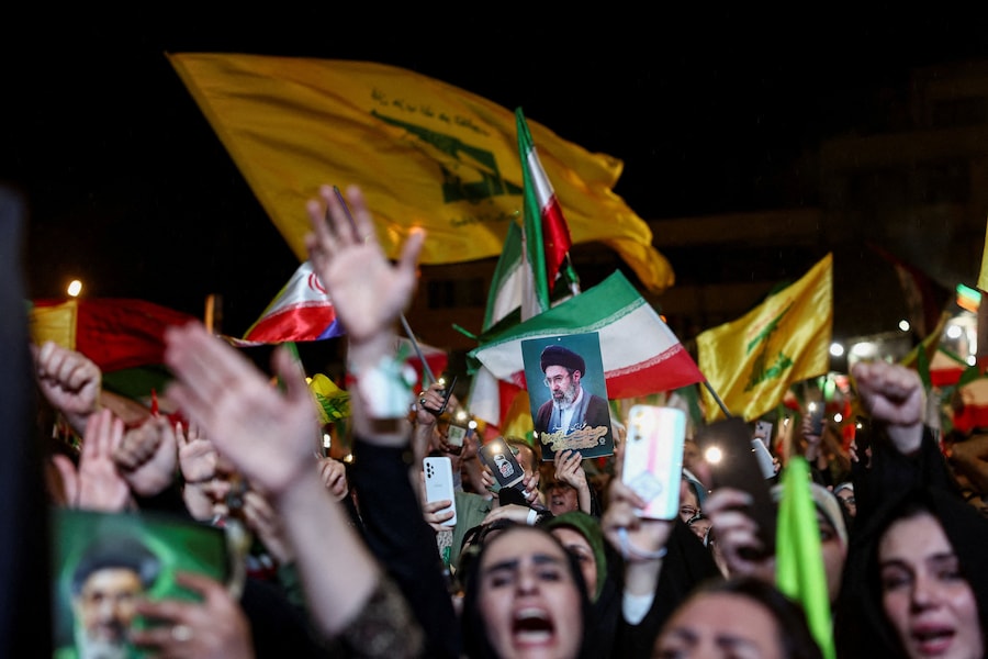 Una donna tiene in mano un’immagine della Guida Suprema iraniana, Mojtaba Khamenei, durante una manifestazione anti-USA e anti-israeliana dopo l’attacco missilistico iraniano contro Israele, a Teheran, Iran (via REUTERS)