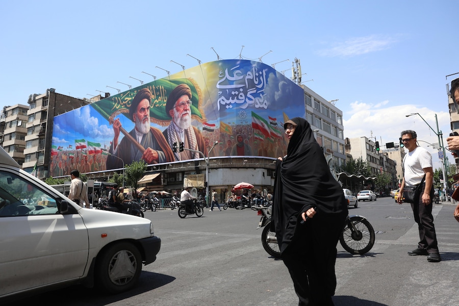 Iraniani passano davanti a un enorme cartellone pubblicitario raffigurante il defunto leader supremo iraniano Ayatollah Ruhollah Khomeini e il leader supremo Ayatollah Ali Khamenei in una strada di Teheran, Iran (EPA)