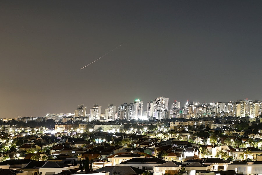 Una scia luminosa illumina il cielo durante un attacco missilistico dall’Iran verso Israele, vista da Ashkelon, Israele (REUTERS)