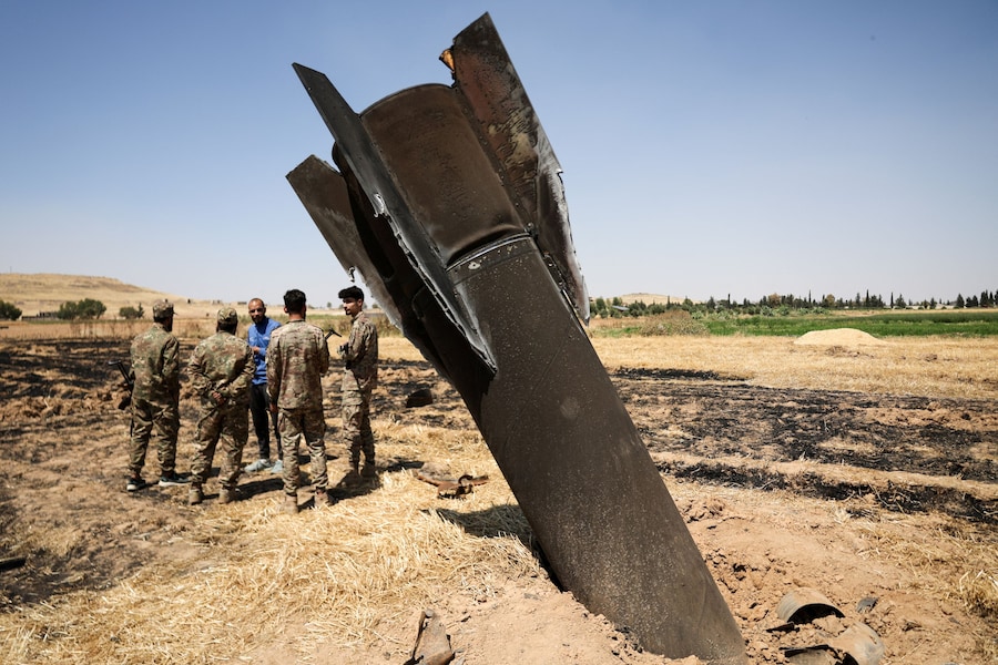 Membri di una squadra di ingegneri militari accanto a un missile iraniano, secondo quanto riferito dalle autorità locali, caduto in una zona rurale vicino a Damasco, in Siria (REUTERS)