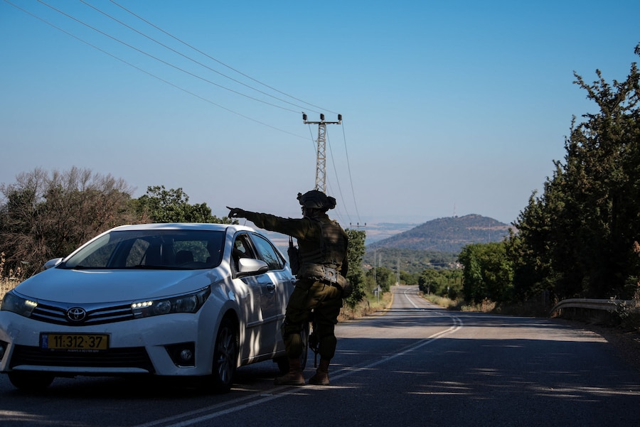 Un soldato israeliano parla con un automobilista, dopo che l’esercito israeliano ha dichiarato di aver ucciso una persona in un incidente in cui ha risposto al fuoco, al confine tra Israele e Libano, nel nord di Israele (REUTERS)