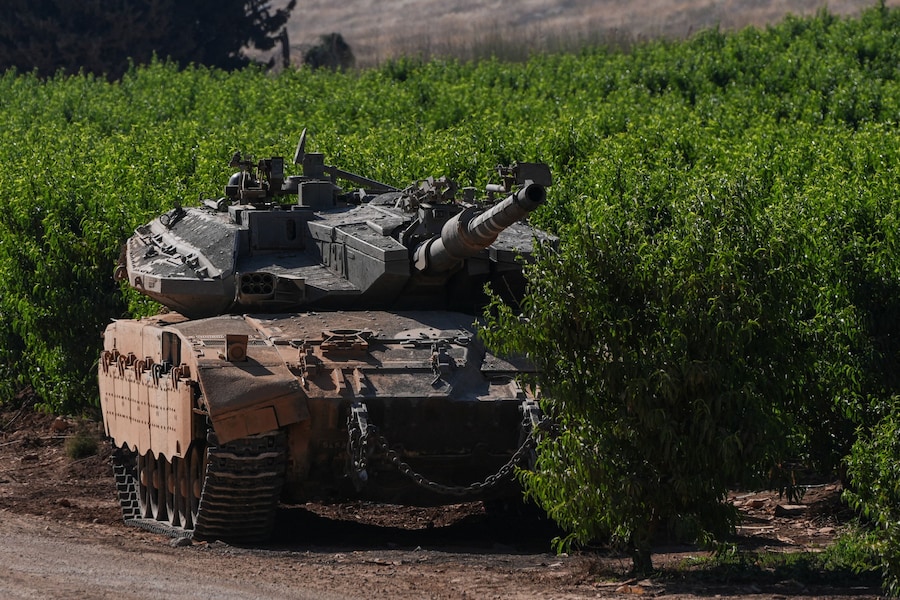 Un carro armato israeliano in una piantagione, vicino al confine tra Israele e Libano, nel nord di Israele (REUTERS)