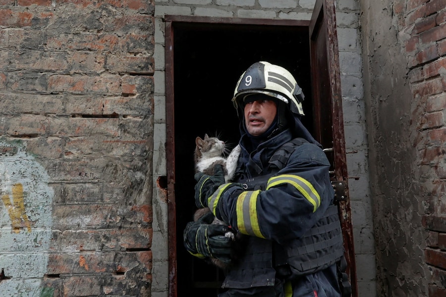 Un vigile del fuoco trasporta un gatto salvato da un condominio colpito da un attacco di un drone russo a Kharkiv, Ucraina (REUTERS)