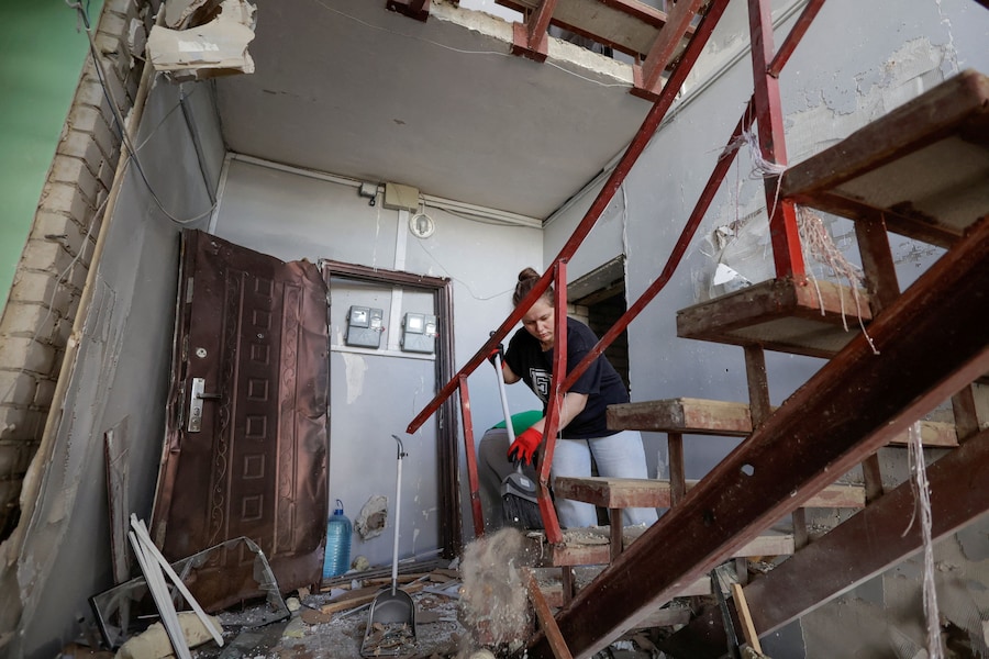 Una residente rimuove le macerie dal suo condominio danneggiato durante gli attacchi notturni dei droni russi nella città di Chuhuiv, nella regione di Kharkiv, Ucraina (REUTERS)