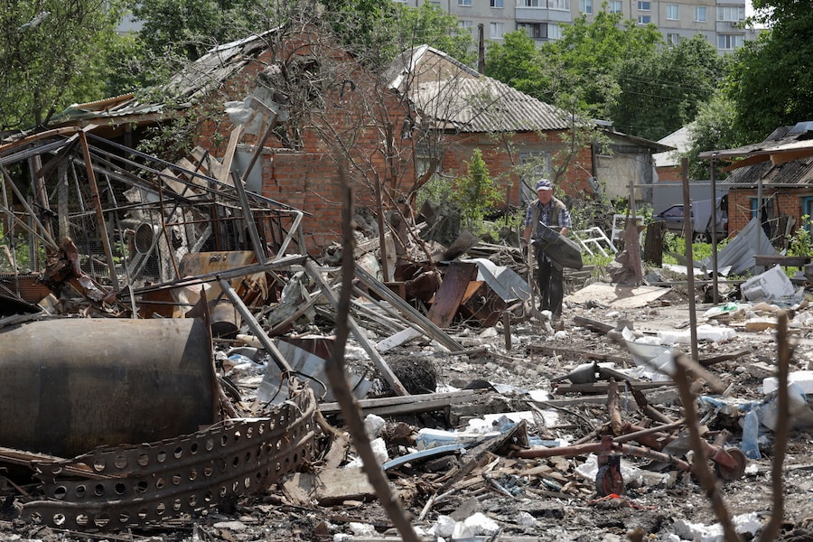 Un uomo rimuove le macerie nel cortile della sua casa danneggiata durante gli attacchi notturni dei droni russi nella città di Chuhuiv, nella regione di Kharkiv, Ucraina (REUTERS)