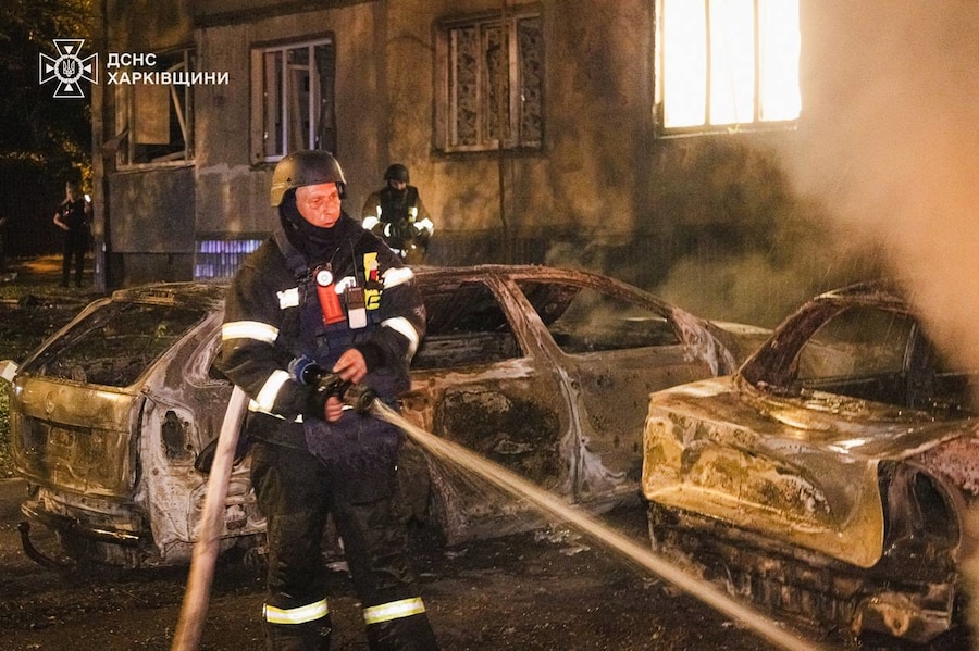 Un soccorritore spegne un incendio divampato tra le auto danneggiate in seguito a un attacco russo a Kharkiv, in Ucraina (APN)