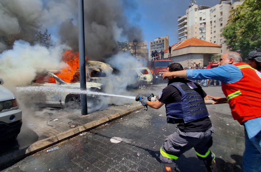 Operatori della Protezione Civile spengono le auto bruciate che sono state colpite da un raid aereo israeliano nella città portuale meridionale di Sidone, Libano (APN)