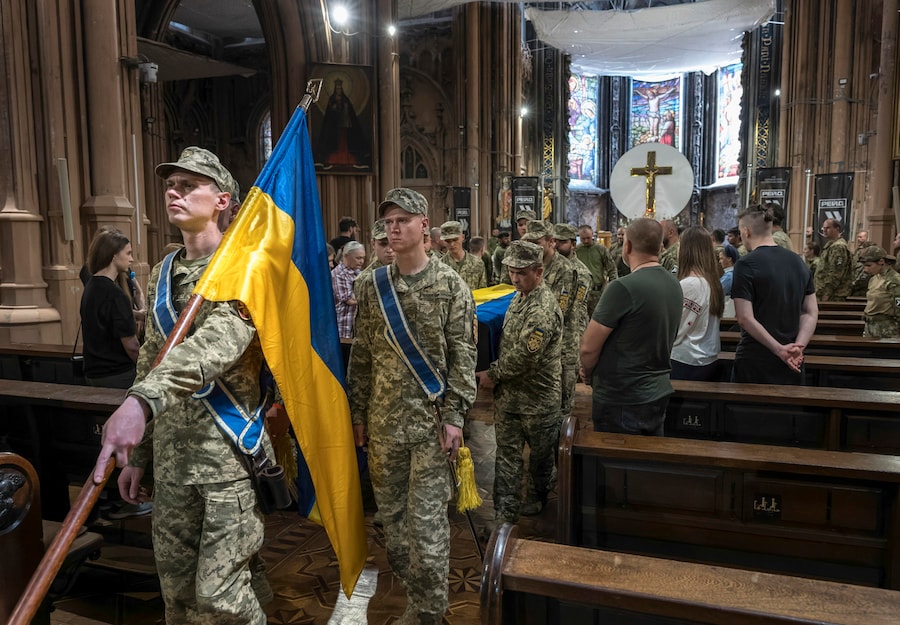 Parenti, amici e compagni partecipano alla cerimonia di addio al volontario colombiano Jan Sebastian Restrepo Mazo nella Cattedrale cattolica romana di San Nicola a Kiev, in Ucraina, l'11 giugno 2026, nel pieno dell'invasione russa. Veterano del Corpo dei Marines colombiano, Restrepo Mazo (nome in codice "Onyx") ha prestato servizio nella Legione Internazionale dell'Ucraina prima di unirsi al 413° Reggimento Sistemi Non Presidiati "Raid". È stato ucciso in combattimento nella regione di Zaporizhzhia. La sua famiglia si è recata dalla Colombia in Ucraina per partecipare alla cerimonia commemorativa. EPA/MAXYM MARUSENKO (EPA)