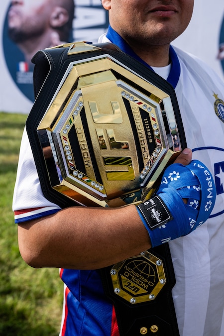 Un partecipante tiene in mano una cintura UFC mentre aspetta in fila durante l'UFC Freedom 250 Fan Fest all'Ellipse di Washington, D.C., Stati Uniti, il 13 giugno 2026. REUTERS/Eric Lee (REUTERS)