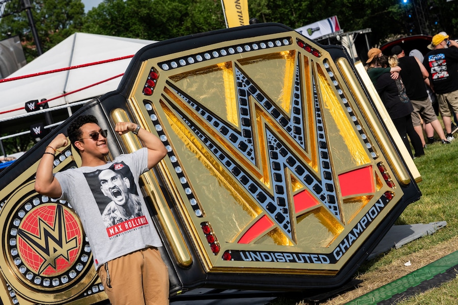 Un partecipante posa accanto alla statuetta della cintura di campione della WWE durante l'UFC Freedom 250 Fan Fest all'Ellipse di Washington, D.C., Stati Uniti, il 13 giugno 2026. REUTERS/Eric Lee (REUTERS)