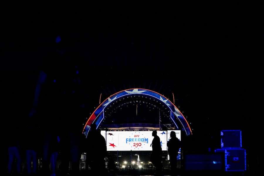 Alcune persone passano davanti a un cartello di UFC Freedom 250 durante la cerimonia di pesatura dei combattenti che partecipano all'evento UFC Freedom 250, presso l'Ellisse vicino alla Casa Bianca, a Washington, D.C., Stati Uniti, il 13 giugno 2026. REUTERS/Nathan Howard (REUTERS)