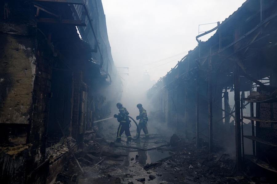 Vigili del fuoco al lavoro sul sito di un mercato colpito da attacchi missilistici e con droni russi a Kiev, Ucraina (REUTERS)