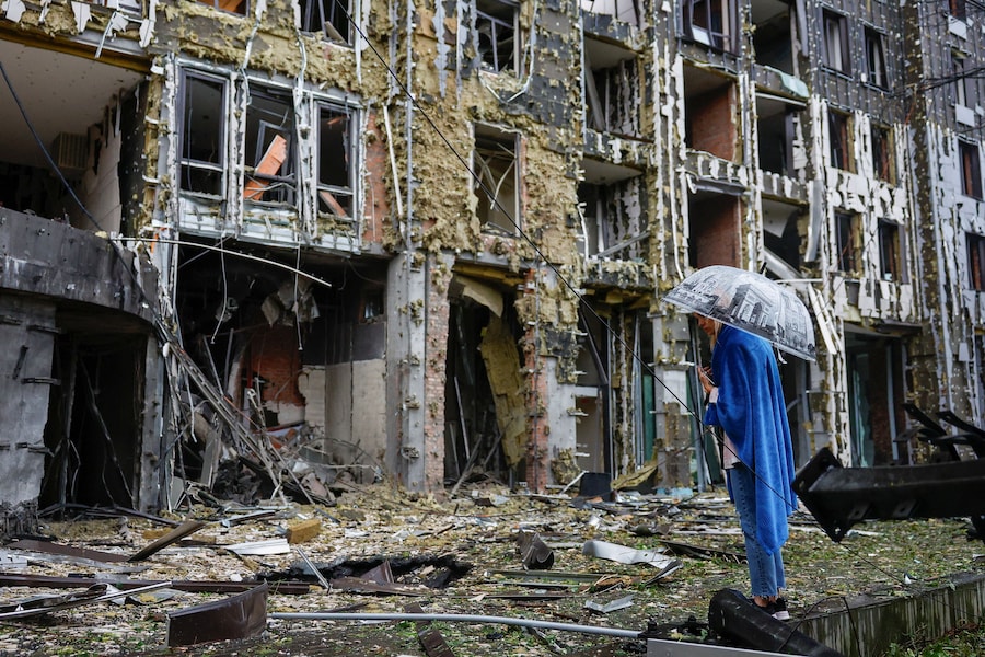 Un residente si trova davanti a un condominio colpito da missili e droni russi a Kiev (REUTERS)