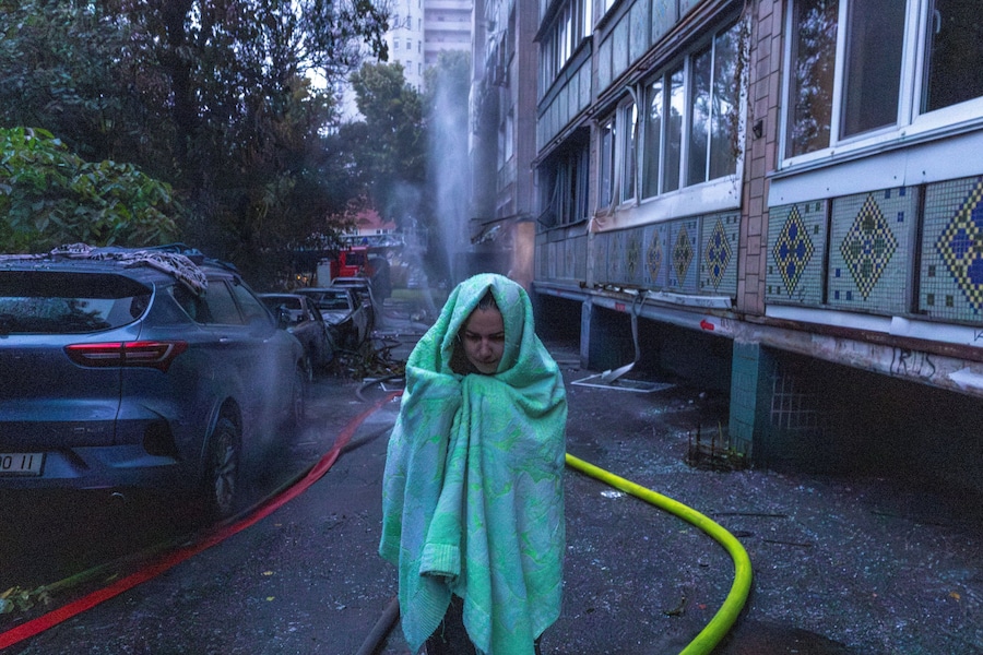 Una donna esce da un condominio colpito da attacchi missilistici e di droni russi a Kiev, Ucraina (REUTERS)