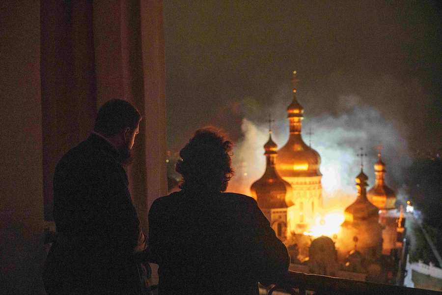 Il vescovo Avraamiy, a destra, del monastero di Kyiv-Pechersk Lavra della Chiesa ortodossa ucraina, osserva la cattedrale della Dormizione in fiamme, nota anche come Monastero delle Grotte, durante un attacco russo su Kiev, in Ucraina (APN)