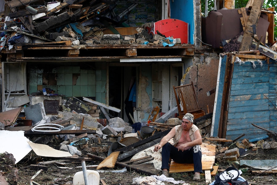 A Kiev un residente è seduto davanti alla sua casa, danneggiata durante gli attacchi russi con missili e droni nel contesto dell'offensiva russa contro l'Ucraina. (REUTERS/Valentyn Ogirenko)