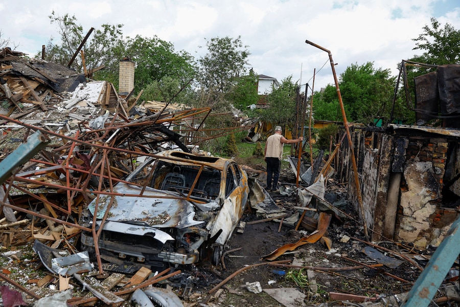 Il residente Vasyl ispeziona il cortile dei suoi vicini, danneggiato durante gli attacchi russi con missili e droni, a Kiev. (REUTERS/Valentyn Ogirenko)