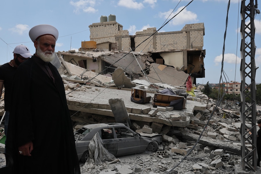 Uno sceicco, appena tornato al suo villaggio, si trova accanto a un edificio distrutto in seguito a un attacco israeliano nel villaggio di Maaroub, nel Libano meridionale, dopo l'annuncio di un accordo quadro preliminare mediato da Stati Uniti e Iran per porre fine alle ostilità militari nella regione e revocare il blocco navale dello Stretto di Hormuz. (EPA/WAEL HAMZEH)