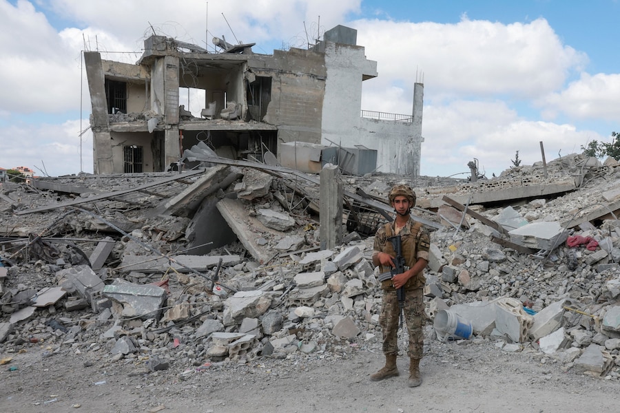 Un soldato dell'esercito libanese monta la guardia tra le macerie degli edifici distrutti, mentre la popolazione torna alle proprie case. (REUTERS/Aziz Taher)