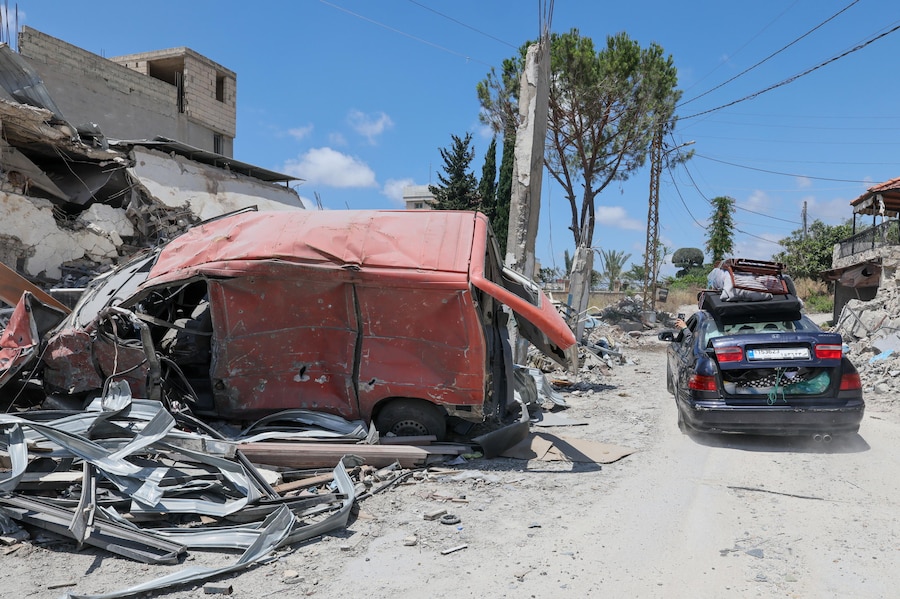 Alcuni sfollati guidano un veicolo carico di materassi mentre tornano nei loro villaggi a Deir Qanoun Nahr, nel Libano meridionale. (EPA/WAEL HAMZEH)