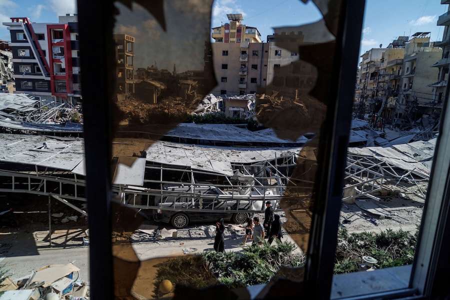 Persone camminano tra le macerie nel luogo di un attacco israeliano a seguito di un accordo tra Stati Uniti e Iran a Tiro, nel Libano meridionale (REUTERS)