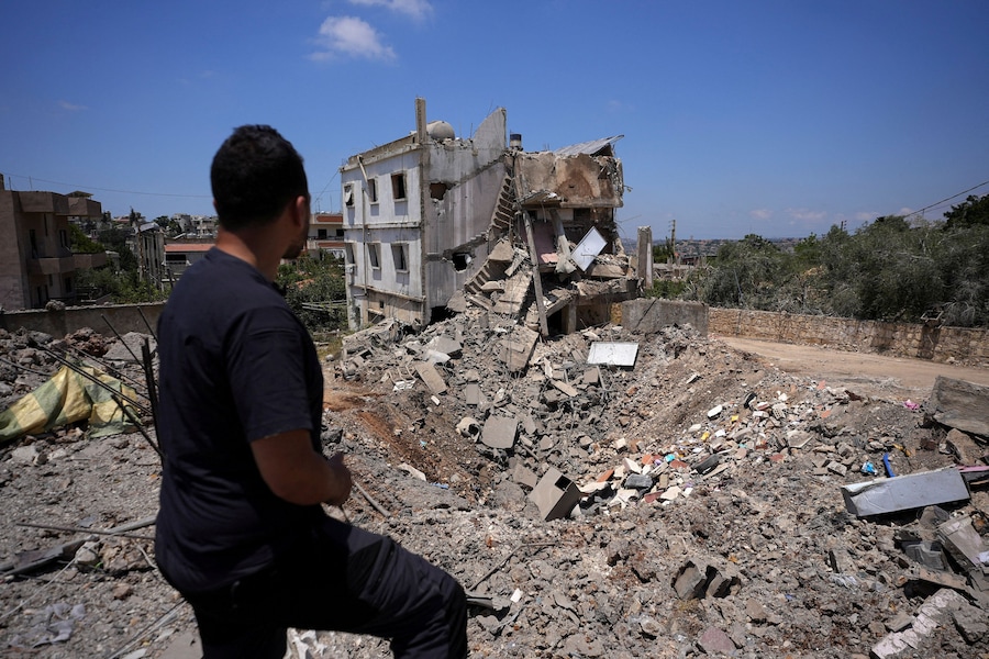 Un uomo osserva il luogo di un precedente attacco israeliano a Kfar Sir, nel distretto di Nabatieh, in Libano (REUTERS)