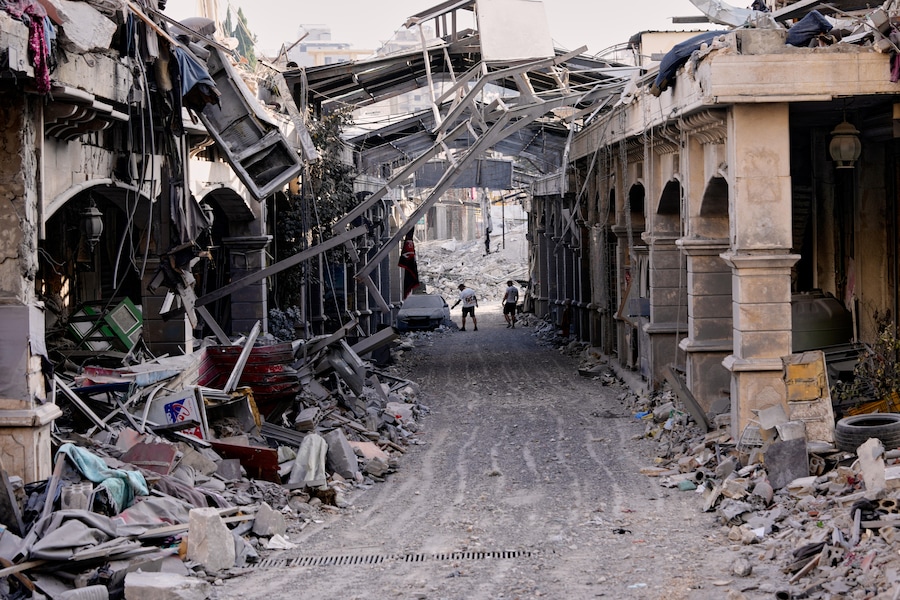Persone che tornano al loro villaggio dopo l’annuncio di un primo accordo di cessate il fuoco tra Stati Uniti e Iran, controllano un’auto presso un negozio distrutto nel mercato di Nabatiyeh, nel Libano meridionale (APN)