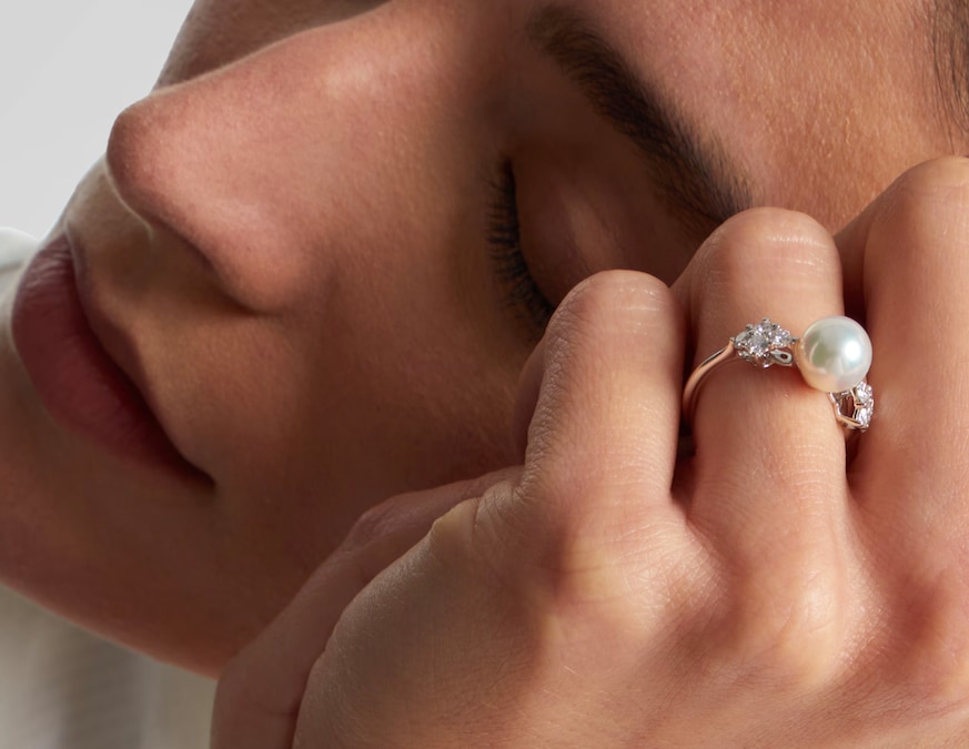 Mikimoto. Anello in oro bianco con perla bianca centrale e diamanti laterali