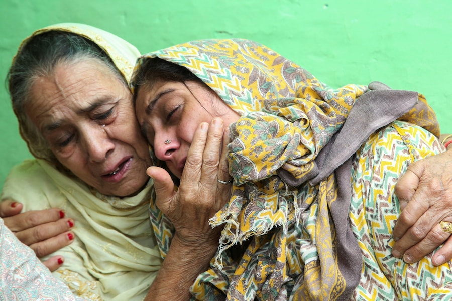 Sushma Sharma, madre di Aditya Sharma, un marinaio indiano a bordo della petroliera MT Settebello, battente bandiera di Palau, che è stato tra i tre membri dell’equipaggio uccisi in un attacco statunitense contro una petroliera con equipaggio indiano durante il blocco navale legato all’Iran, piange mentre viene consolata da un familiare nella sua casa di Hamirpur, Himachal Pradesh, India (REUTERS)
