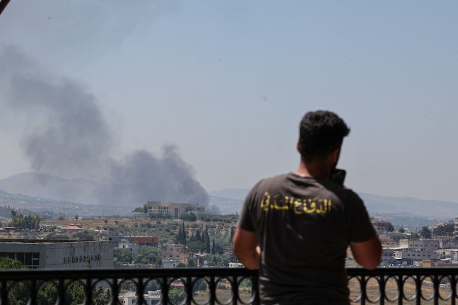 Un membro della protezione civile è in piedi mentre il fumo si leva dal sud del Libano, visto da Nabatieh, in seguito agli attacchi israeliani, Libano (REUTERS)
