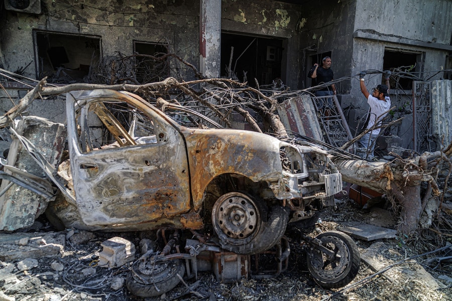 Ahmad Fares, 40 anni, venditore di antiquariato online, esce dalla casa di famiglia, in cui ha vissuto per oltre 70 anni e che è stata danneggiata da un raid aereo israeliano, mentre il suo amico Sharif Safiaddine, 33 anni, tenta di riparare i cavi elettrici, a Tiro, nel sud del Libano (REUTERS)