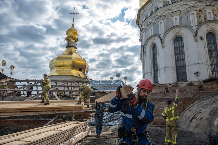 I soccorritori ucraini intraprendono lavori di conservazione sul tetto danneggiato della Cattedrale della Dormizione nel Monastero delle Grotte di Kiev (Kyiv Pechersk Lavra) a Kiev, dopo l’attacco russo (EPA)