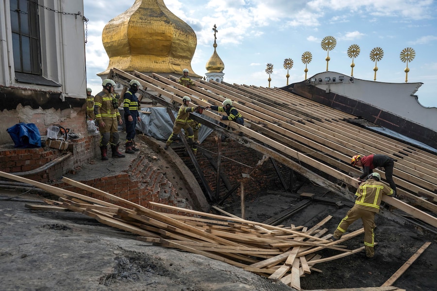 I soccorritori ucraini intraprendono lavori di conservazione sul tetto danneggiato della Cattedrale della Dormizione nel Monastero delle Grotte di Kiev (Kyiv Pechersk Lavra) a Kiev, dopo l’attacco russo (EPA)