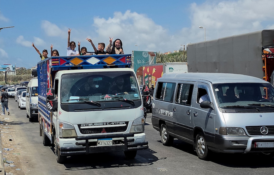 Dei bambini salutano con la mano dal retro di un camion bloccato nel traffico, mentre la gente si dirige più a sud in seguito all’accordo tra Stati Uniti e Iran, a Sidone, in Libano. (REUTERS/Ali Hankir)