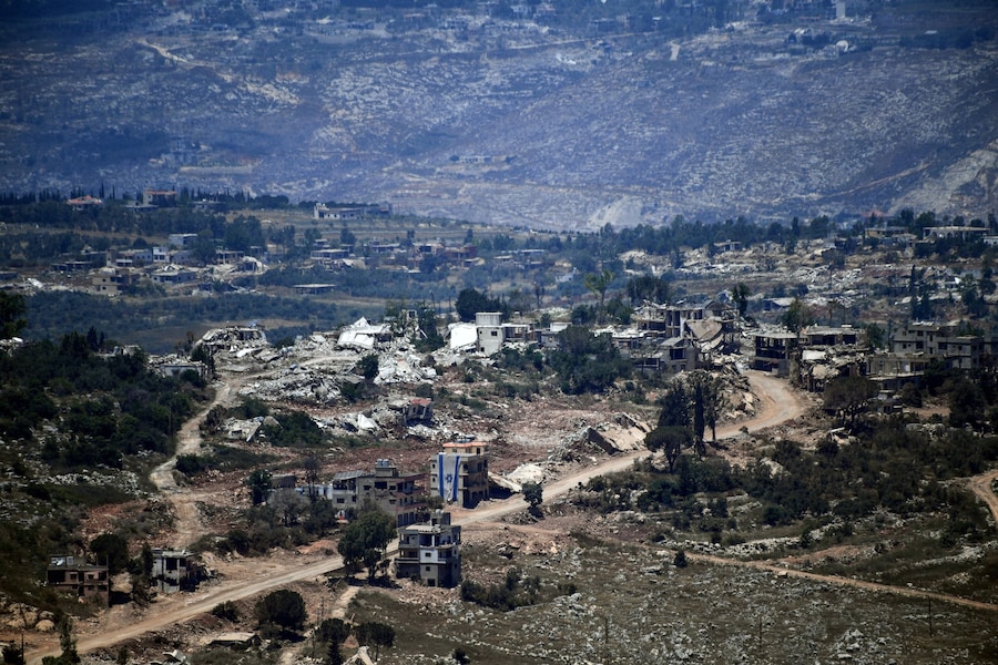 Una bandiera israeliana sventola da un edificio danneggiato in un villaggio nel sud del Libano, vicino al confine, vista dal nord di Israele. (REUTERS/Gil Eliyahu)