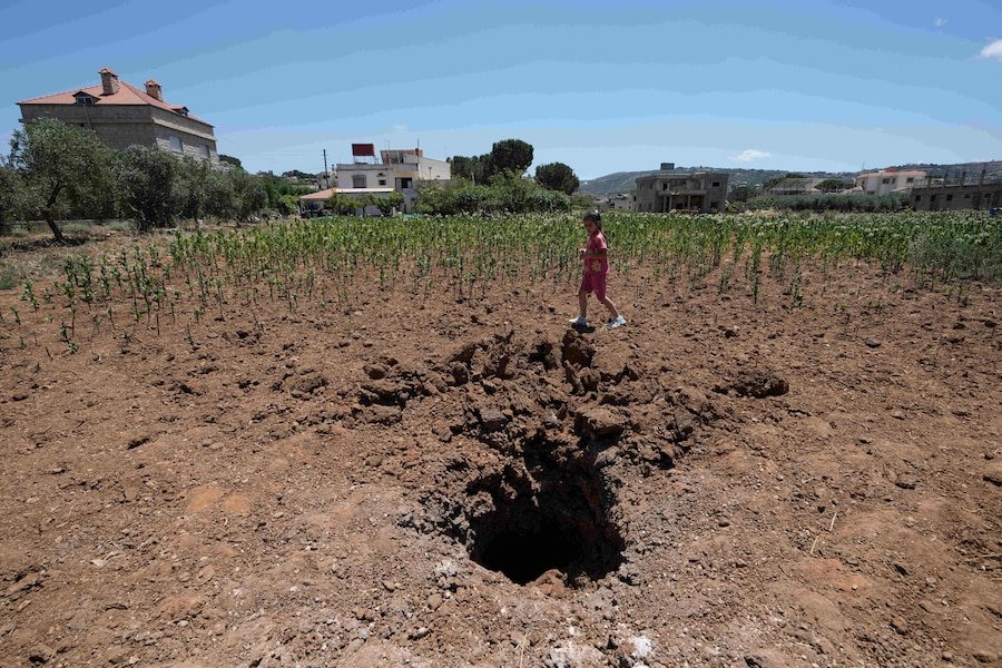 Angela Elias, 7 anni, osserva un cratere causato da un razzo caduto nella fattoria della sua famiglia nel villaggio cristiano di Rmaych, nel sud del Libano. (AP Photo/Bilal Hussein/Associate Press/ LaPresse/APN)