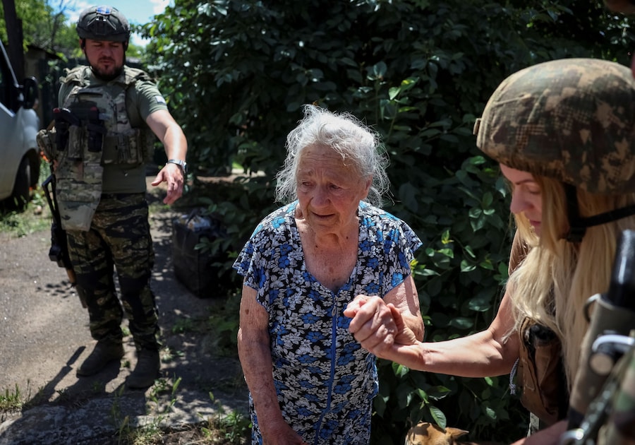 Un membro dell’unità di evacuazione della polizia “White Angels” e un volontario assistono Lydia Coglaeva, 87 anni, durante un’evacuazione dalla città di Druzhkivka, situata in prima linea, nel contesto dell’attacco russo all’Ucraina, nella regione di Donetsk. (REUTERS/Anatolii Stepanov)