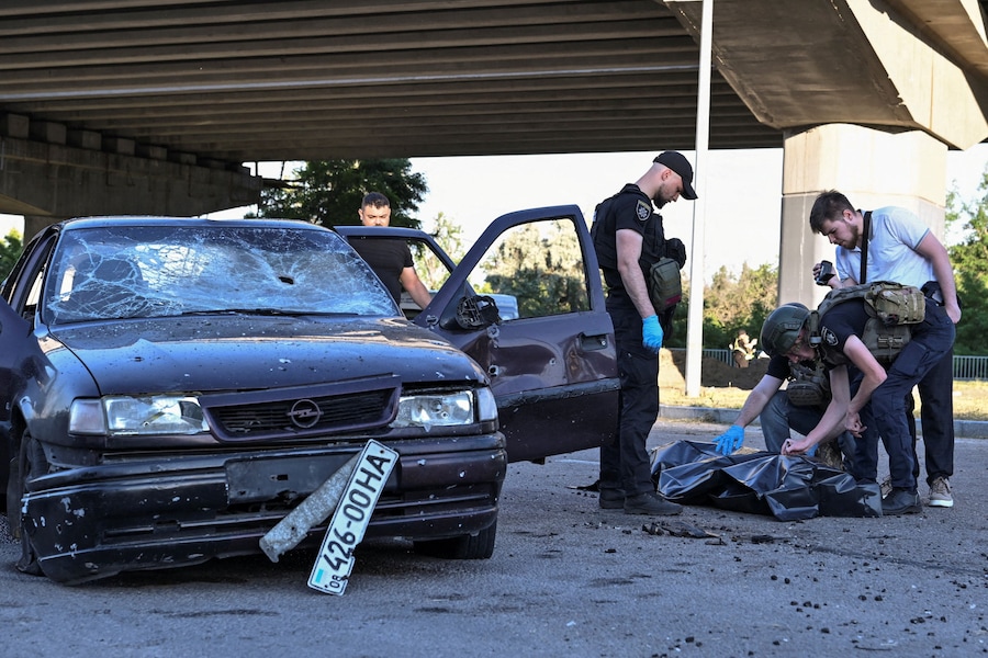 Gli agenti di polizia ripongono il corpo di una donna in un sacco per cadaveri dopo che è stata uccisa all’interno di un’auto da un attacco aereo russo, nel contesto dell’offensiva russa contro l’Ucraina, a Zaporizhzhia. (REUTERS/Stringer)