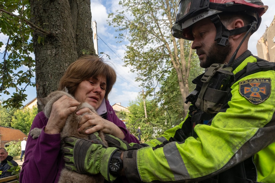 Un vigile del fuoco consegna a una donna il suo gatto, ritrovato durante le operazioni di ricerca e soccorso nell’edificio residenziale danneggiato in seguito all’attacco missilistico russo a Kharkiv. (AP Photo/Andrii Marienko/Associated Press/ LaPresse/APN)