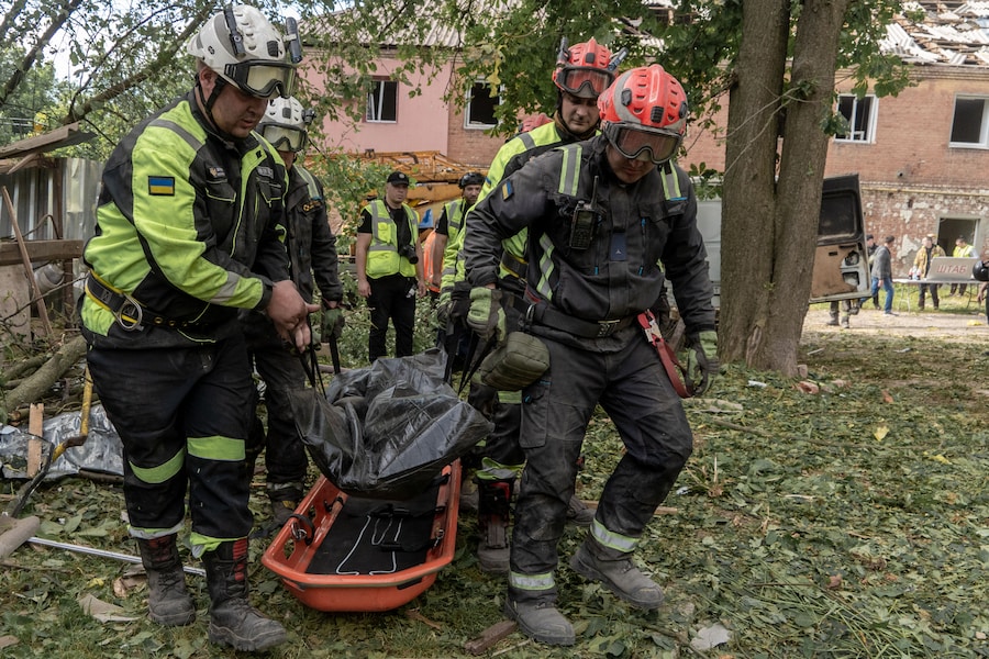 I soccorritori trasportano un corpo che hanno recuperato dalle macerie di un condominio in seguito all'attacco missilistico russo a Kharkiv. (AP Photo/Andrii Marienko/Associated Press/ LaPresse/APN)