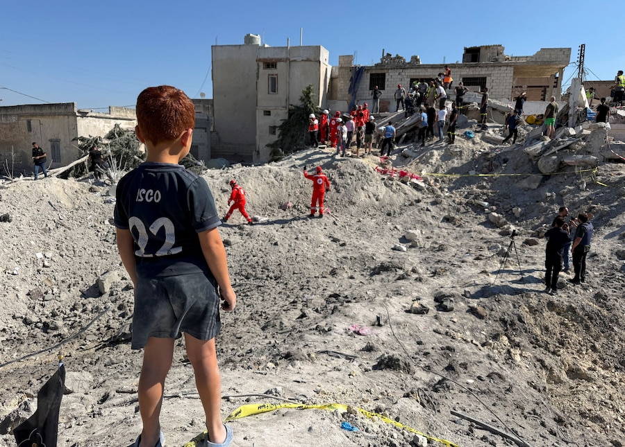 Un bambino in piedi accanto alle macerie di un edificio danneggiato da un attacco israeliano a Qennarit, nel Libano meridionale. (REUTERS/Stringer)